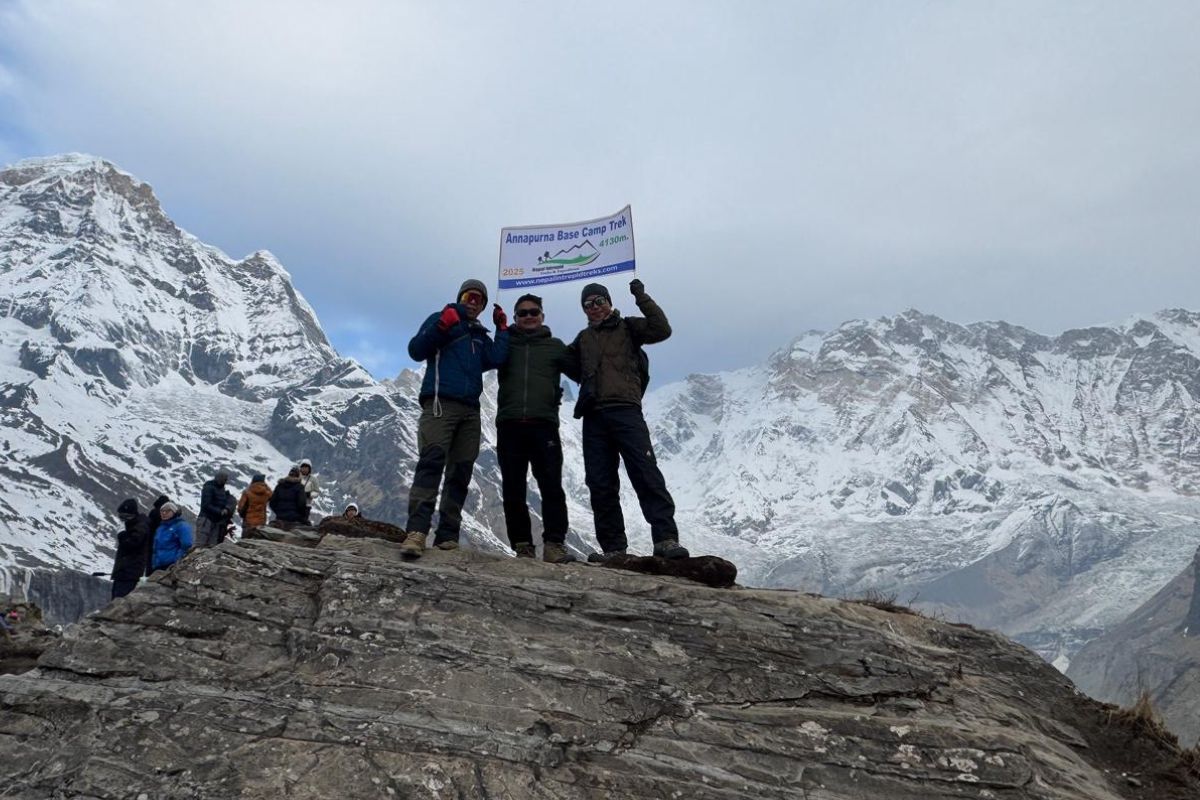 Three People With Annapurna Base Camp Trek Brochure